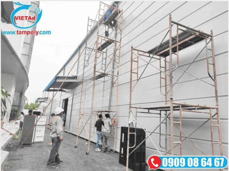 Công nhân đang lắp đặt tấm panel tôn xốp cho mặt ngoài nhà xưởng