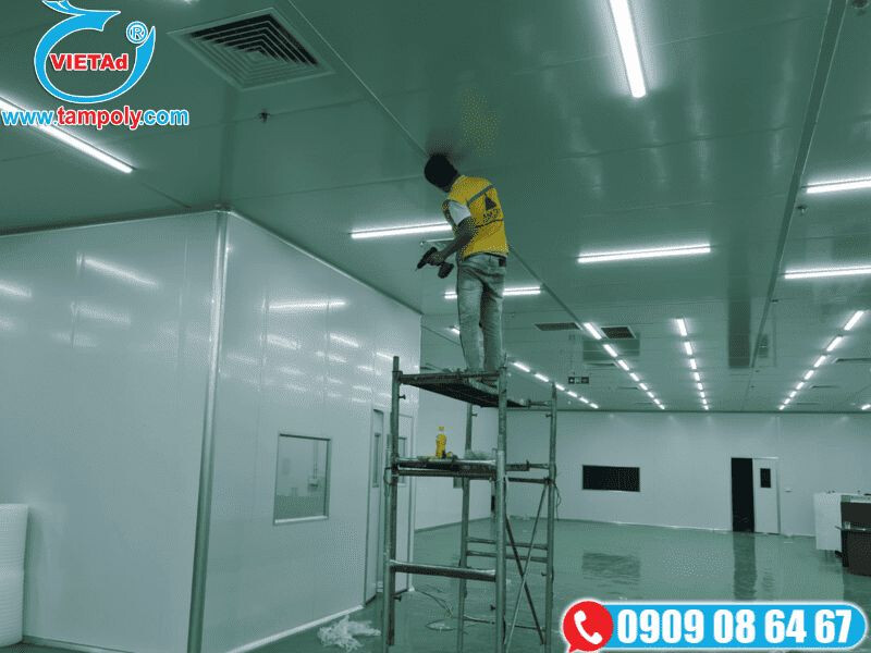 Công nhân đang thi công lắp đặt trần panel tôn xốp trong không gian nhà xưởng