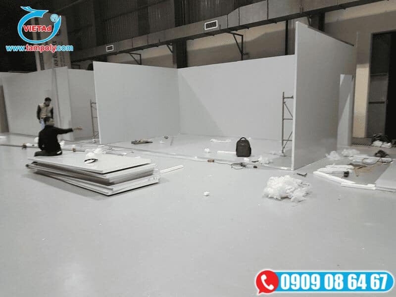 Thi công vách ngăn tại nhà xưởng với các tấm vách ngăn trắng, công nhân đang làm việc