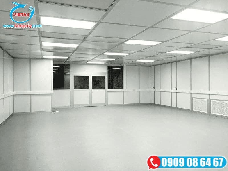 Quá trình lắp đặt tấm panel tại kho xưởng, với công nhân thực hiện thao tác trên bộ cửa lớn màu sáng.