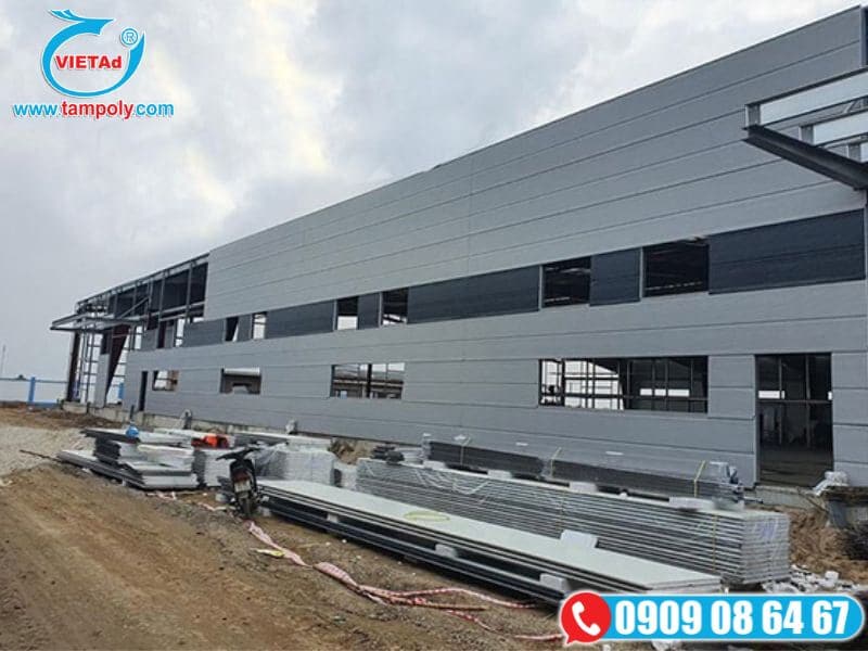 Công nhân thi công lắp tấm paenl cách nhiệt bên ngoài nhà xưởng
