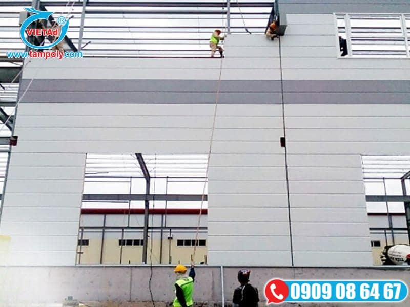 Công nhân đang thi công lắp đặt tấm panel cách nhà xưởng ngoài trời 