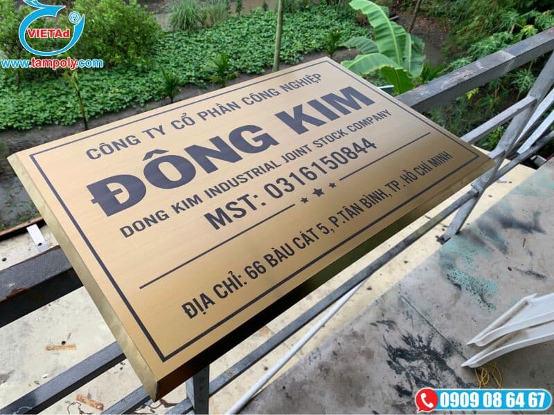 Bảng hiệu công ty bằng inox vàng xước, chữ ăn mòn màu đen.