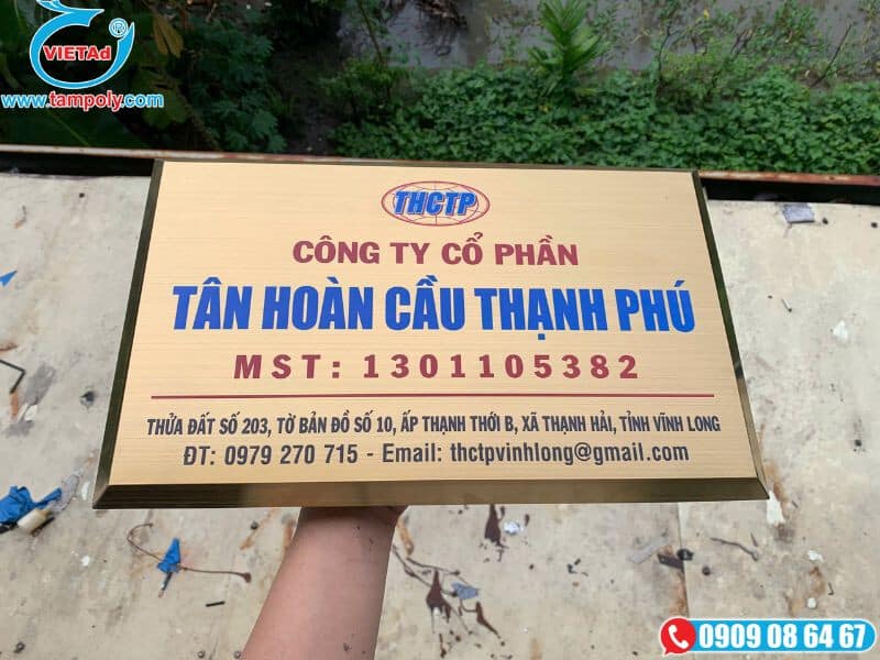 Bảng hiệu inox vàng xước, chữ ăn mòn màu đỏ và xanh.