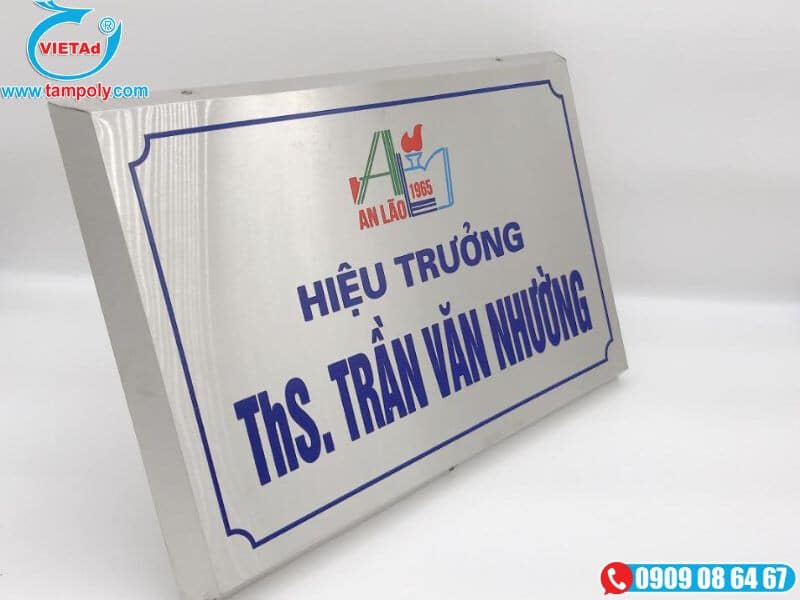 Nền inox trắng bạc xước, chữ ăn mòn xanh dương, viền xanh và logo màu nổi bật.