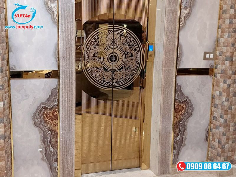 Tấm inox vàng gương khắc họa tiết lên cửa thang máy